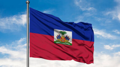 Flag Of Haiti Waving In The Wind Against White Cloudy Blue Sky. Haitian Flag.