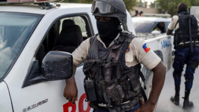 Haitian National Policemen guard the entrance to the U.S. Embassy as people gather to ask for asylum following the assassination of President Jovenel Moise