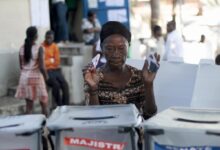 A woman asks where to deposit her ballots at a polling station in Port au Prince, Haiti