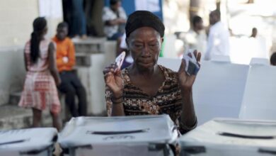 A woman asks where to deposit her ballots at a polling station in Port au Prince, Haiti