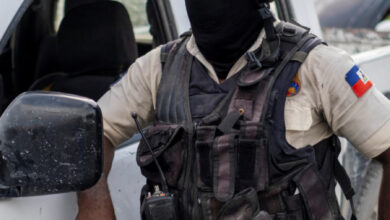 Haitian National Policemen guard the entrance to the U.S. Embassy as people gather to ask for asylum following the assassination of President Jovenel Moise